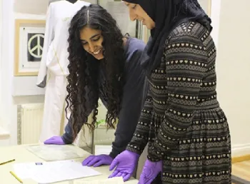 Hanna Ahmed (left) and Nazish Majid looking at items from the archive at The Peace Museum, Bradford