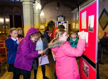 A group of school pupils make notes while taking part in a church trail