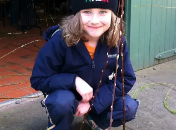 A young person taking part in willow weaving 