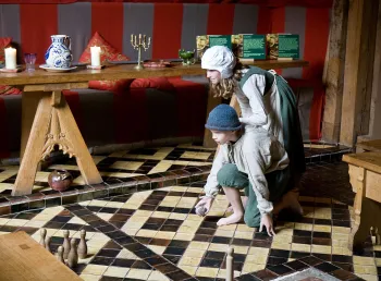 Children dressed in Tudor costume playing skittles in Barley Hall