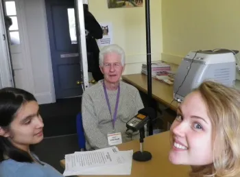 Two students interviewing an older person