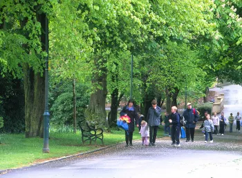 Adults and children walk in Tollcross Park