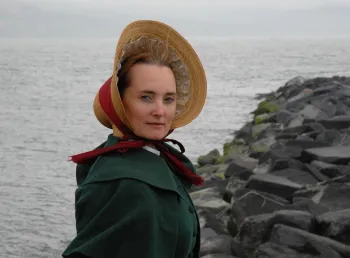 An actor in traditional dress standing on the Jurassic Coast