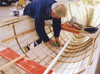 A volunteer working on boat restoration