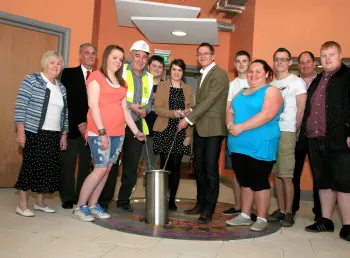 Young people placing their time capsule into the floor of their youth club