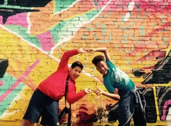 Young people pose by graffiti art
