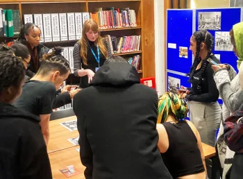 A group of people working around a table looking at research materials