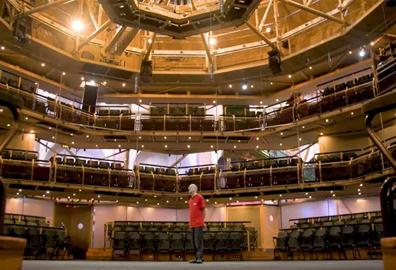 A man standing inside a vast theatre