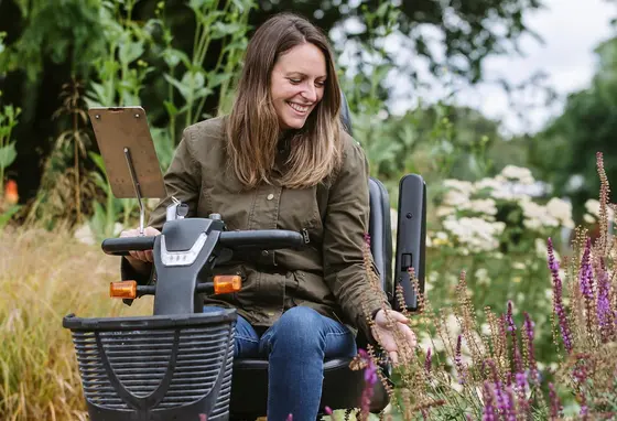 3)	A visitor using a mobility scooter in the Wellbeing Garden at RHS Garden Wisley