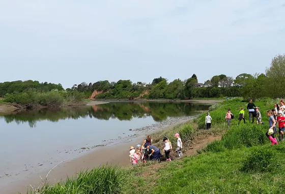 Children taking part in activities by the river edge
