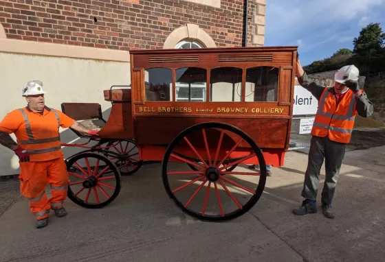 Horse-drawn ambulance at Land of Iron. Credit: Land of Iron Two workmen standing either side of the horse-drawn ambulance