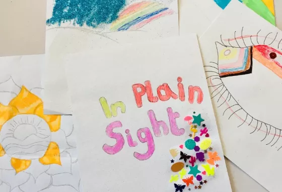 In Plain Sight poster Colourful handmade poster for the In Plain Sight project. Rainbows, flowers and an eye decorated with LGBTQ+ colours can be seen