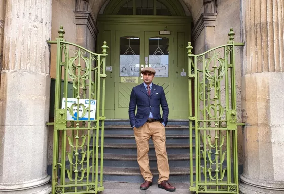 Man standing in front of the doorway of an old school building
