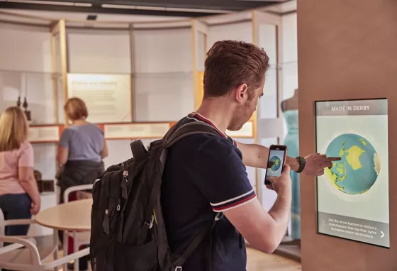 Man taking a picture of himself using a touchscreen at an interactive exhibition