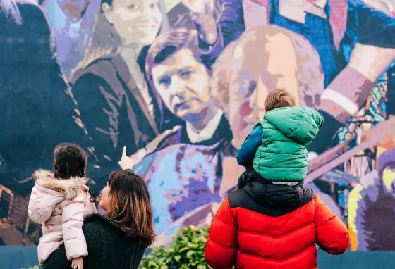 Connecting communities in Northern Ireland with their local heritage Two adults and two children looking at a wall mural