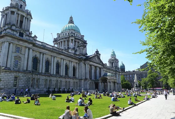 Shared History Fund: bringing people together to mark Centenary of Northern Ireland People sitting on grass in front of large building