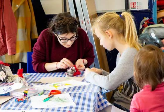 Stories of Eastern European community live on, thanks to emergency funding Woman making crafts with children