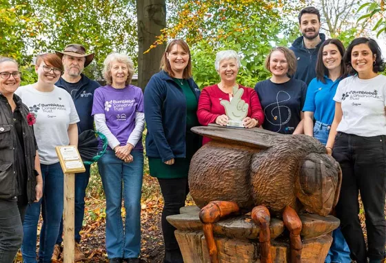 Submit your heritage nominations for this year's National Lottery Awards Group of people stand next to each other, smiling at the camera whilst holding an award