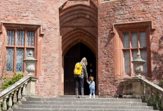 Adult and child entering historic building.