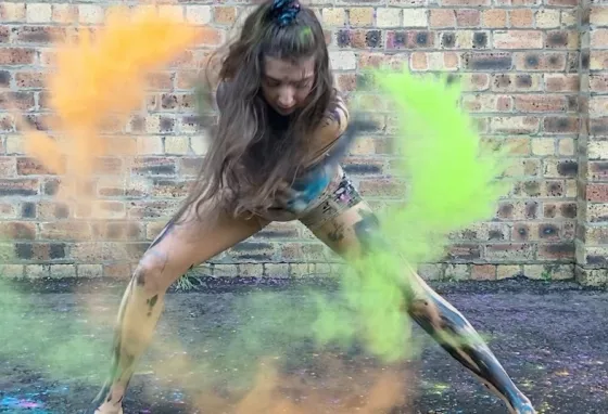 A young Shaper/Caper dancer from Dundee performs with coloured, powdered paint