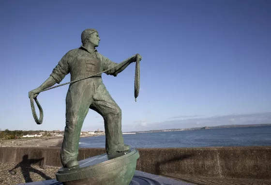 Sculpture of a fisherman holding a rope and looking out to sea