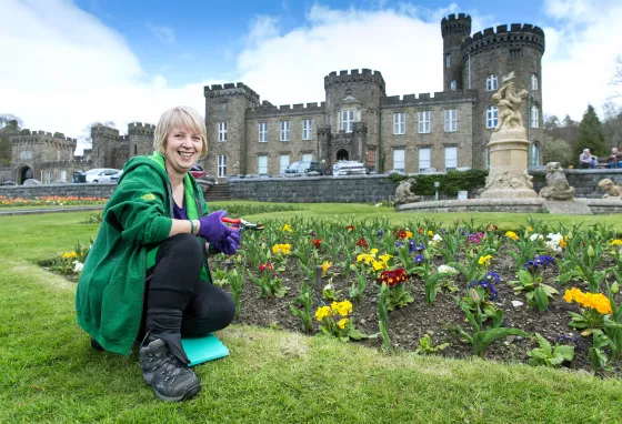 Changing lives: Angela's root to recovery Woman crouching in grounds of a castle