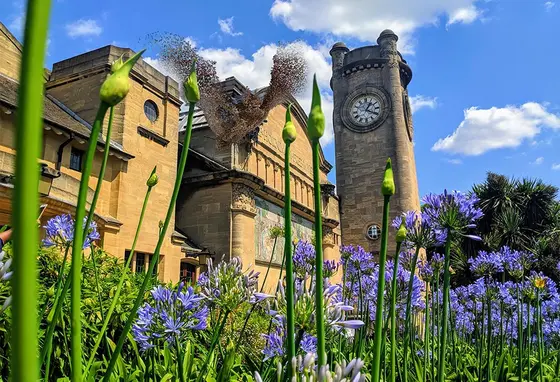 The Horniman Museum featuring a clock tower stands tall behind greenery