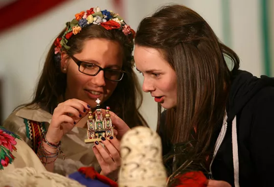 Two young women examining a figurine