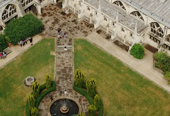 An ariel view of the green space on Gloucester Cathedral grounds with people exploring