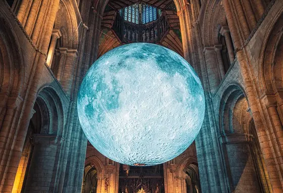A large artwork of the moon hanging in Ely Cathedral