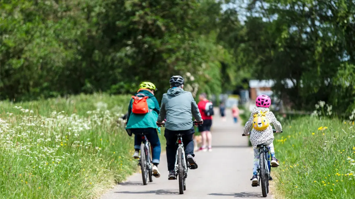 A family cycle on a road on a day out to a heritage site