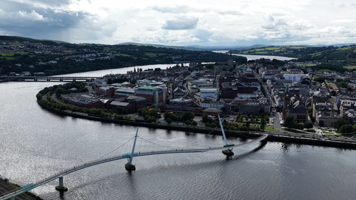 An aerial view of Derry/Londonderry showing the Peace Bridge and the River Foyle