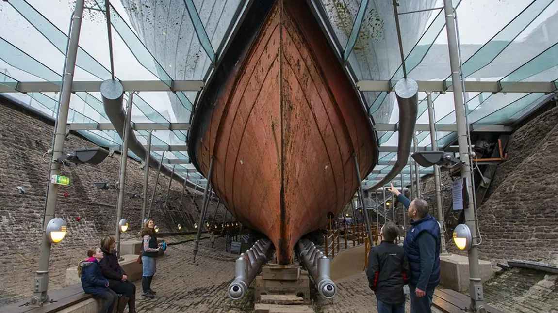 People look up at the hull of SS Great Britain from within the dry dock