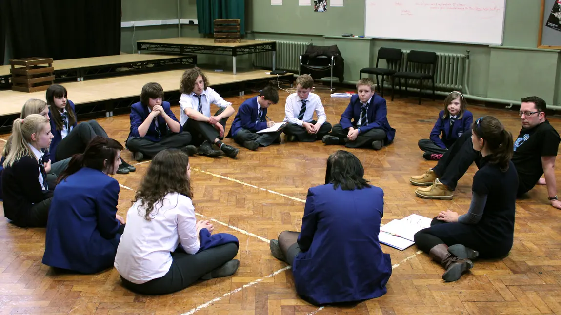Students discuss ideas in a circle 