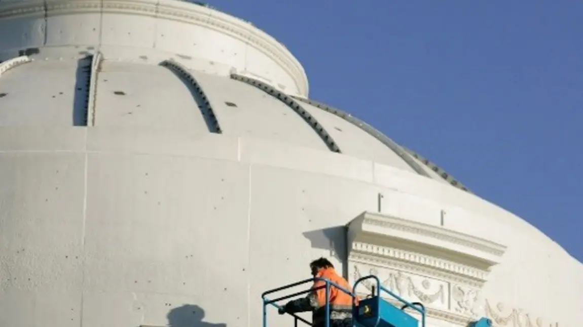 A worker repairing the Fergusson Gallery's 19th-century cast iron dome roof