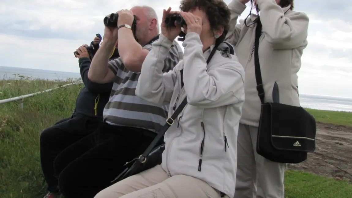 Participants of the Following Fred project using binoculars