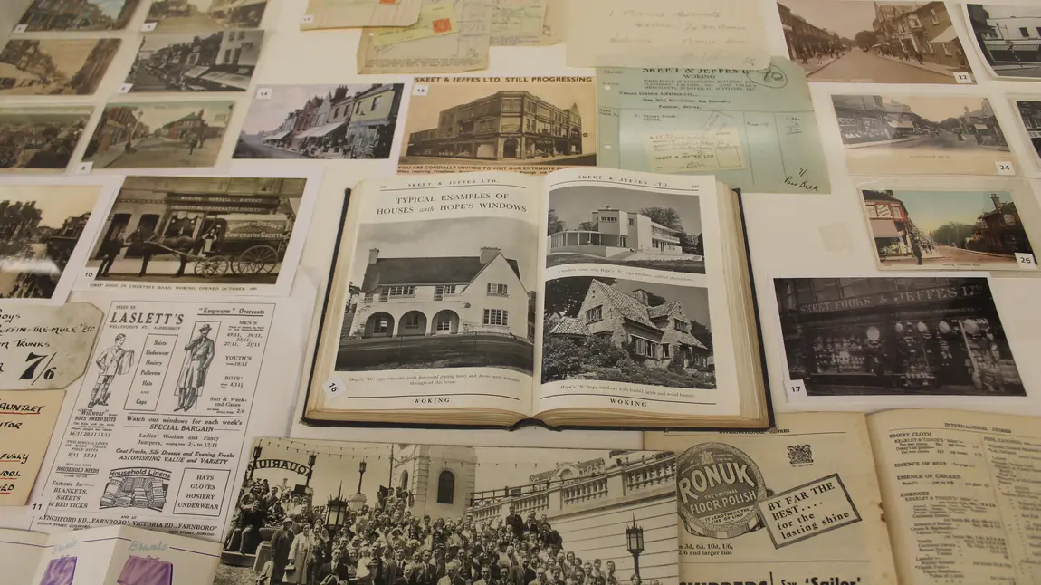 Heritage display for 'Woking's Story' exhibit, a collection of vintage postcards and books