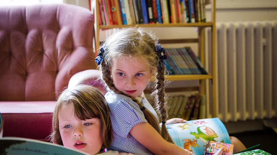Two children read books as part of a Reader session