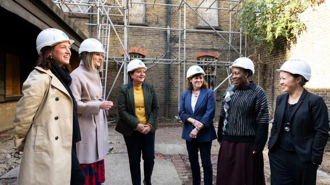 Visiting work commencing at Alice Billings House. Group of people wearing hard hats in a courtyard of historic building, Alice Billings House in Stratford
