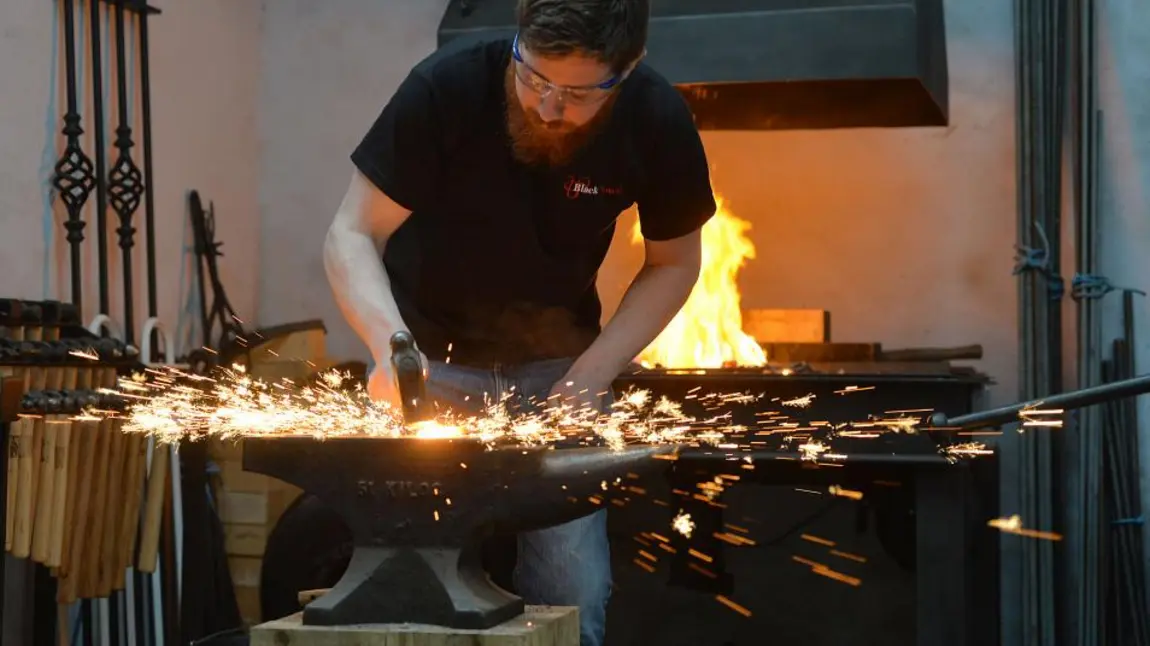 A blacksmith striking metal, with sparks flying