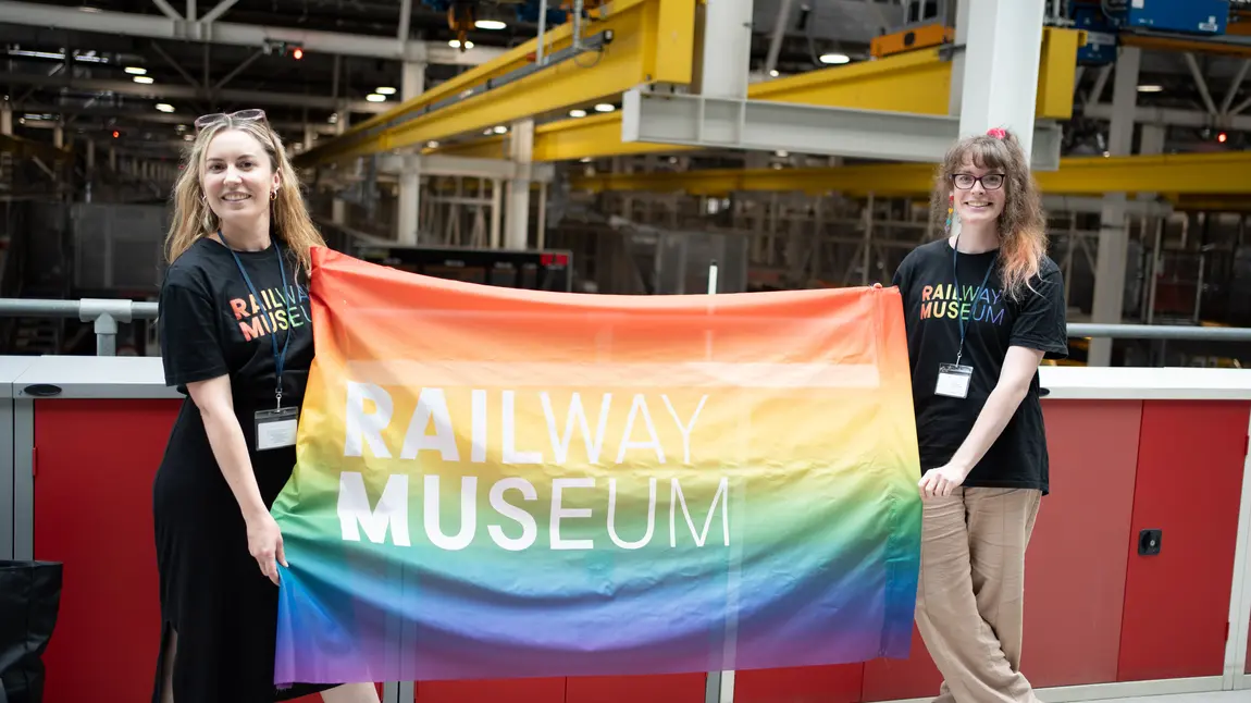 Two people holding a Pride flag