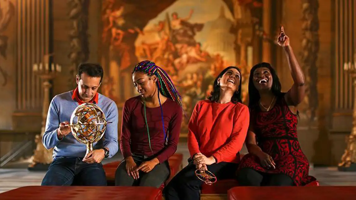 Four people sitting with large artwork behind them