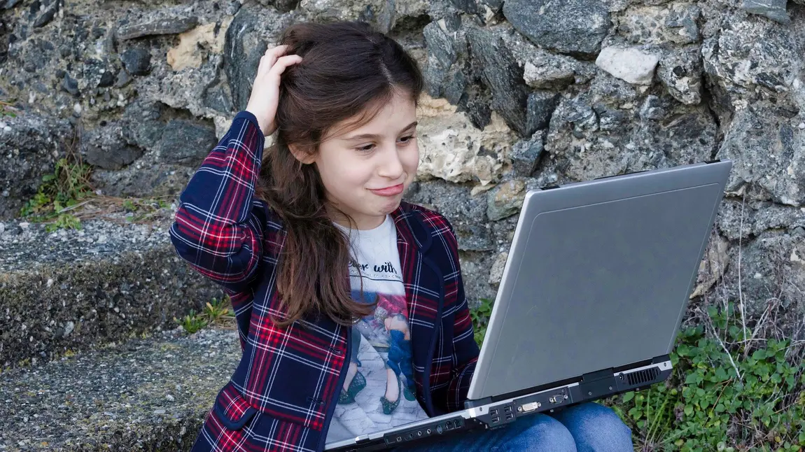 Young person looking at phone on beach