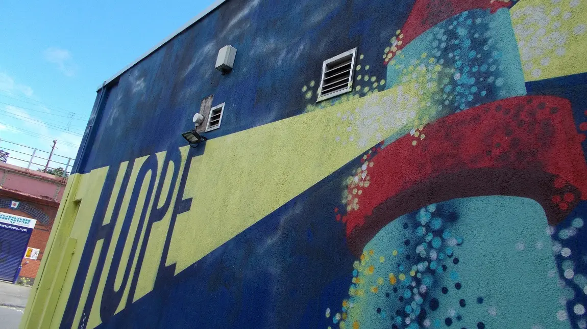A photo of a wall painting, showing a lighthouse with the word 'hope'