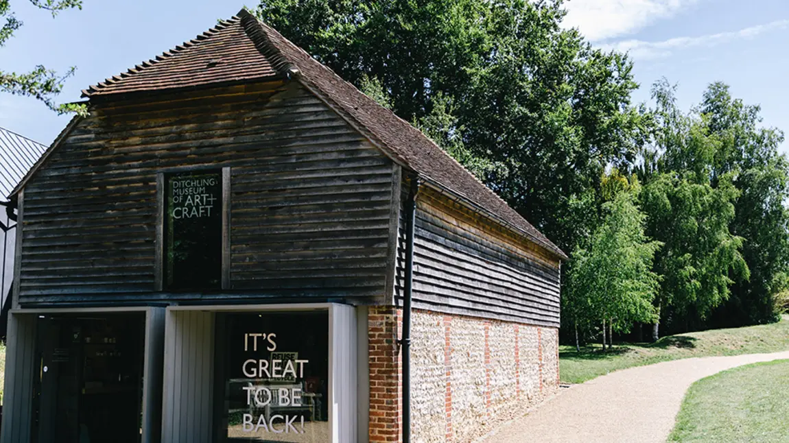 Exterior of Ditchling Museum with sign saying 'it's good to be back'.