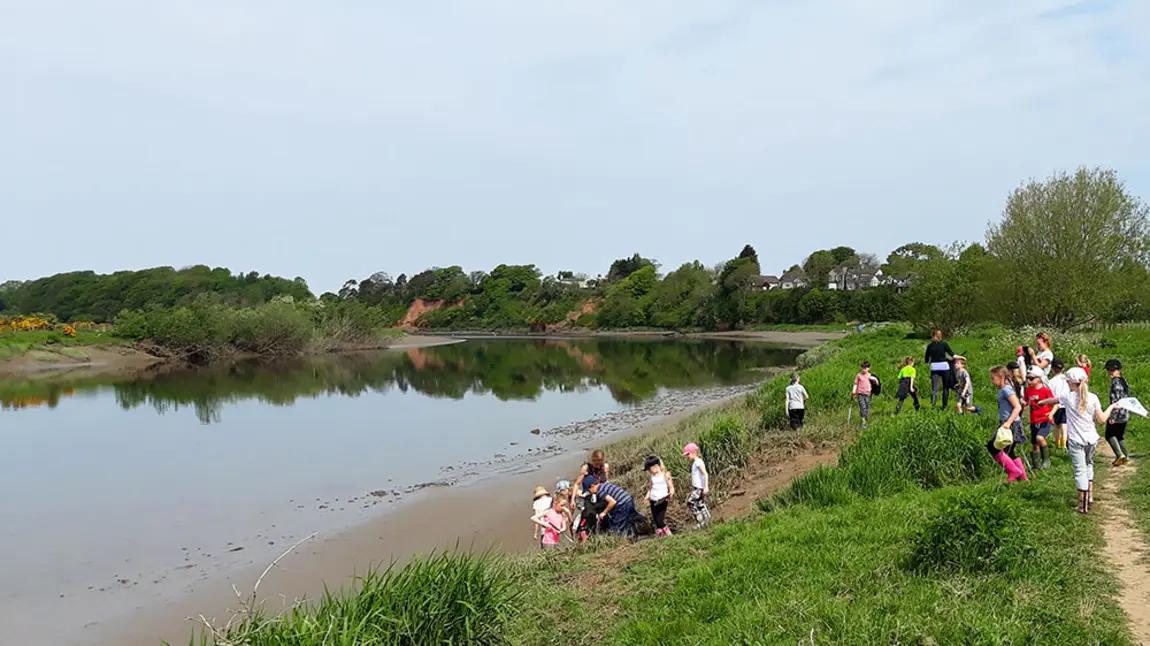 Children taking part in activities by the river edge