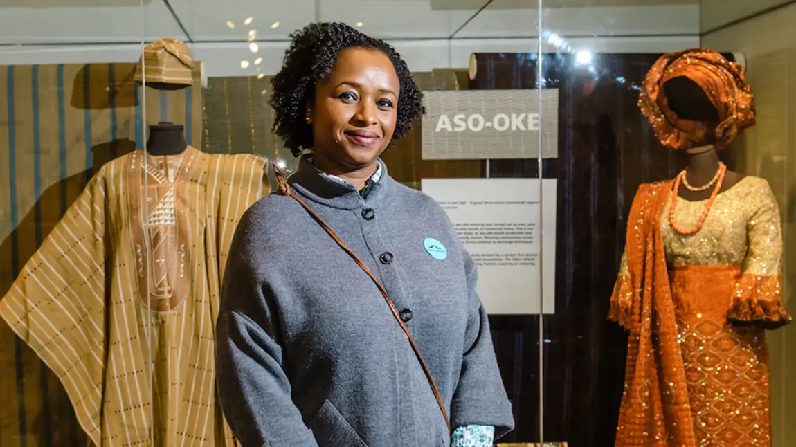 A curator in front of display of African costume