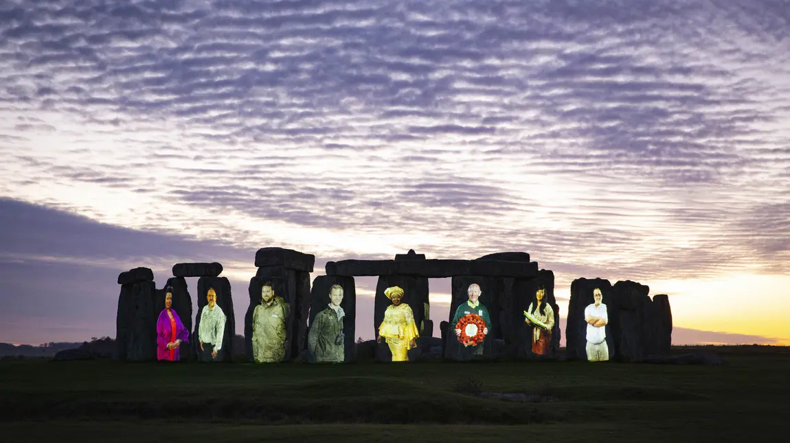 Stonehenge at sunset illuminated with eight people