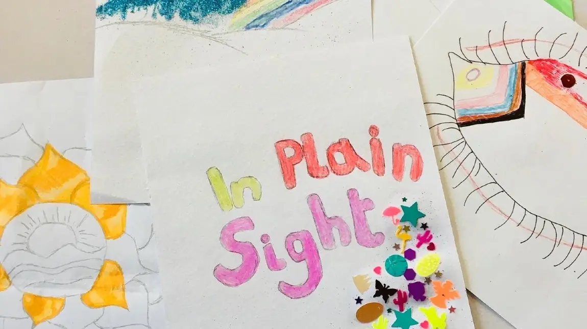Colourful handmade poster for the In Plain Sight project. Rainbows, flowers and an eye decorated with LGBTQ+ colours can be seen