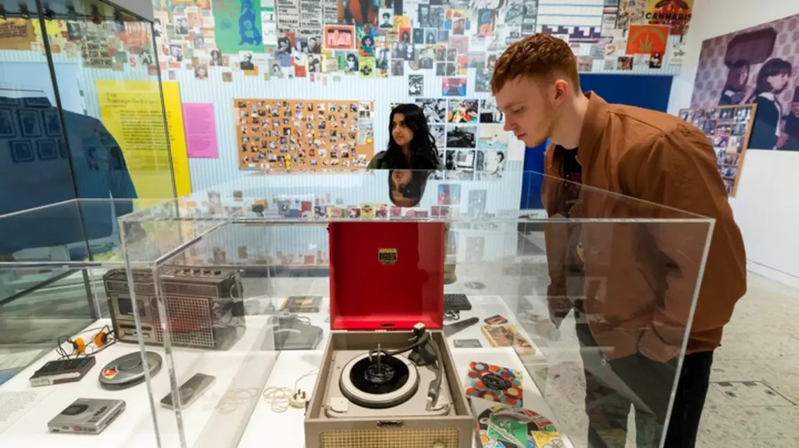 Museum of Youth image showing a person looking at a record player in a display